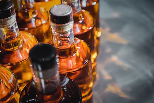 Small liquor production based on maple syrup. Multitude of pure alcohol bottles\\n not labeled. Bottles placed in a row.