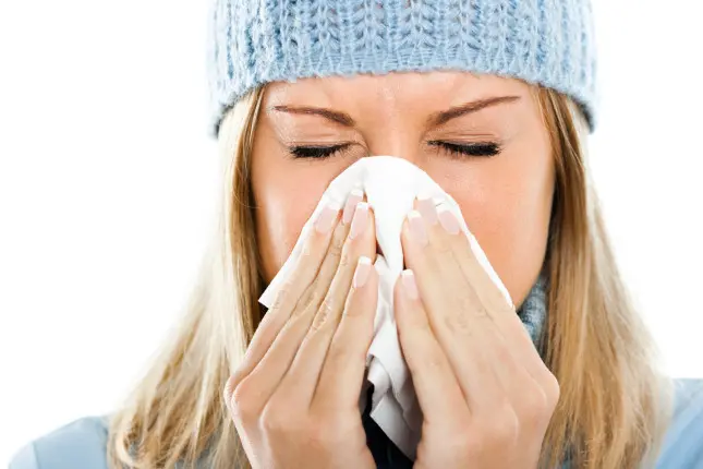 Young woman blowing into tissue