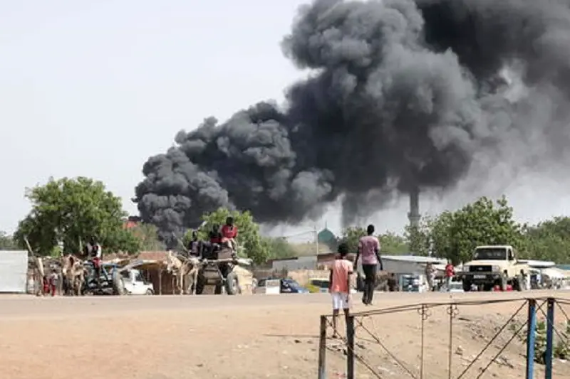 epa10625669 People drive as smoke rises from a fire at a market in the Upper Nile State town of Renk, South Sudan, 13 May 2023. According to UNHCR, at least 40,000 people have arrived into South Sudan since armed clashes between Sudan\\'s military and rival paramilitary groups began in Khartoum and other parts of the country on 15 April 2023. Most of the refugees are part of the some 800,000 South Sudanese who had previously fled the war in South Sudan and who are now returning to a country with tensions still remaining in many areas, and more than two million internally displaced people. Upon arriving at the Joda border crossing, the refugees head to a transit area set up by UNHCR in the small town of Renk, where various UN agencies assist them with registration, food, health check and logistics.  EPA/AMEL PAIN