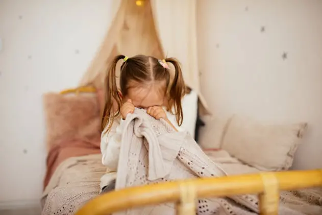 Portrait of unhappy small girl indoors, crying.