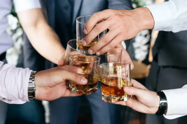 Cropped view of Group of friends guys with glasses of whiskey before wedding day