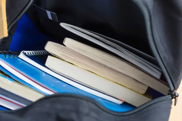 Backpack with schoolbooks and notebooks. Education concept image. Selective focus