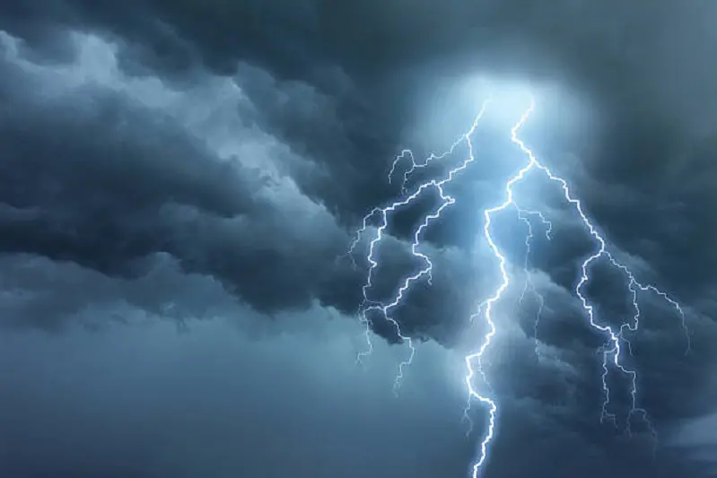 <p>Bright lightning illuminates dark cloudy sky during a thunderstorm. Natural dangers and majestic beauty. Real cloudscape with computer generated lightning. Copy space on image side.</p>\\n