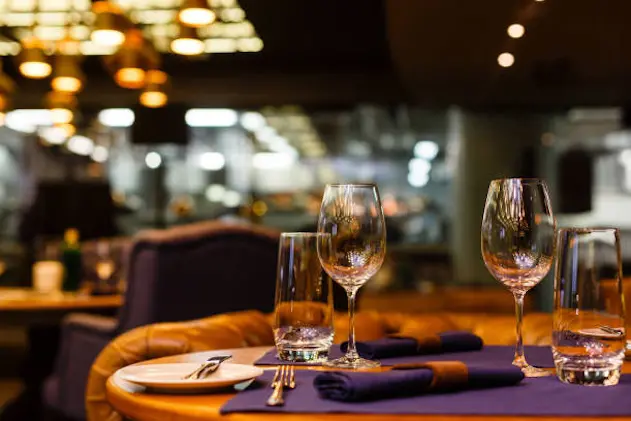 Two empty wine glasses sitting in a restaurant on a warm sunny afternoon.