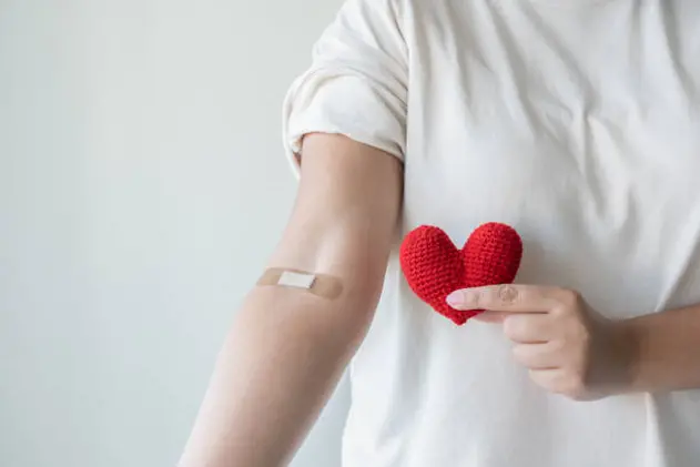 Blood donation concept. Give blood save up to three lives. Woman arm with the bandage plaster showing as a blood donation volunteer.