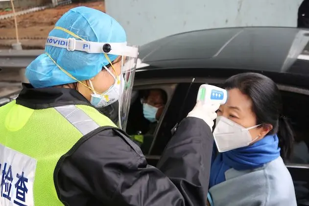 A security officer in a protective mask checks the temperature of a passenger following the outbreak of a new coronavirus, at an expressway toll station on the eve of the Chinese Lunar New Year celebrations, in Xianning, a city bordering Wuhan to the north, Hubei province, China January 24, 2020. REUTERS/Martin Pollard
