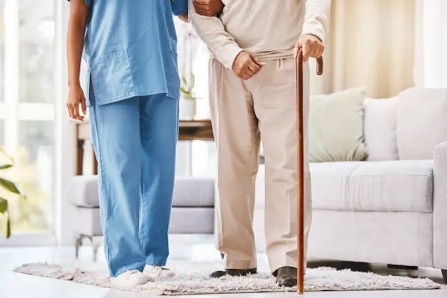 Walking stick, nursing home and senior patient with medical help, support and therapy for disability, cancer and arthritis. Cane, elderly disabled man and caregiver for sick, osteoporosis and service