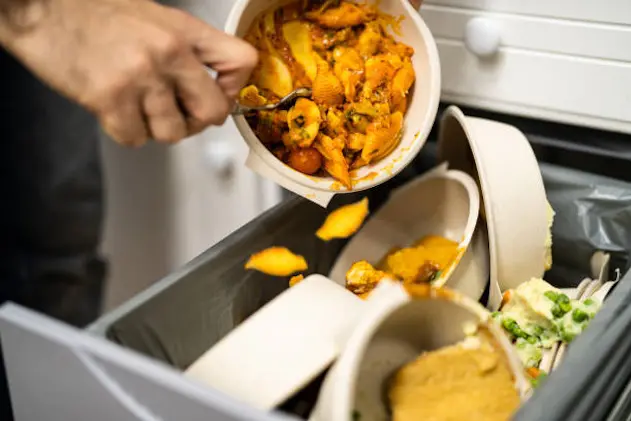 Throwing Away Leftover Food In Trash Or Garbage Dustbin