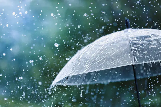 Transparent umbrella under heavy rain against water drops splash background. Rainy weather concept.