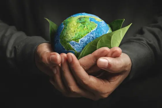 World Earth Day Concept. Green Energy, Renewable and Sustainable Resources. Environmental and Ecology Care. Hand Embracing Green Leaf and Handmade Globe