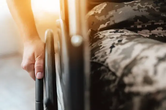 Woman veteran in wheelchair returned from army. Close-up photo veteran woman in a wheelchair. Wheelchairs and legs in military uniform.