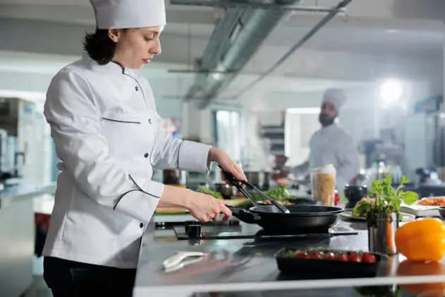 Gastronomy expert cooking gourmet dish for dinner service in restaurant while preparing food in professional kitchen. Head chef cooking meal using fresh and organic ingredients while using pan.