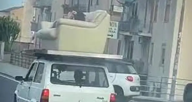A spasso per Catania sdraiato su un divano sul tetto di una Panda: multato