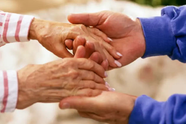 Man holding elderly woman\\'s hands