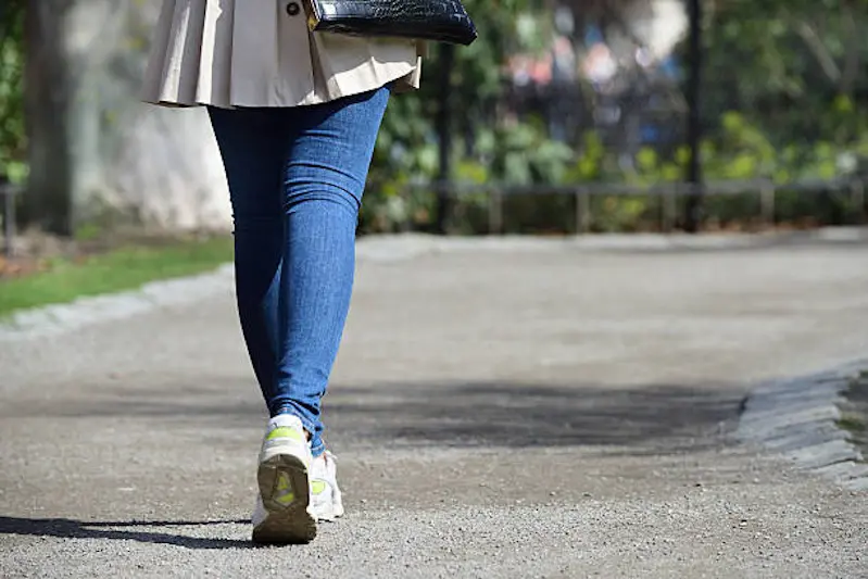 Young woman with nice handbag walking in the park