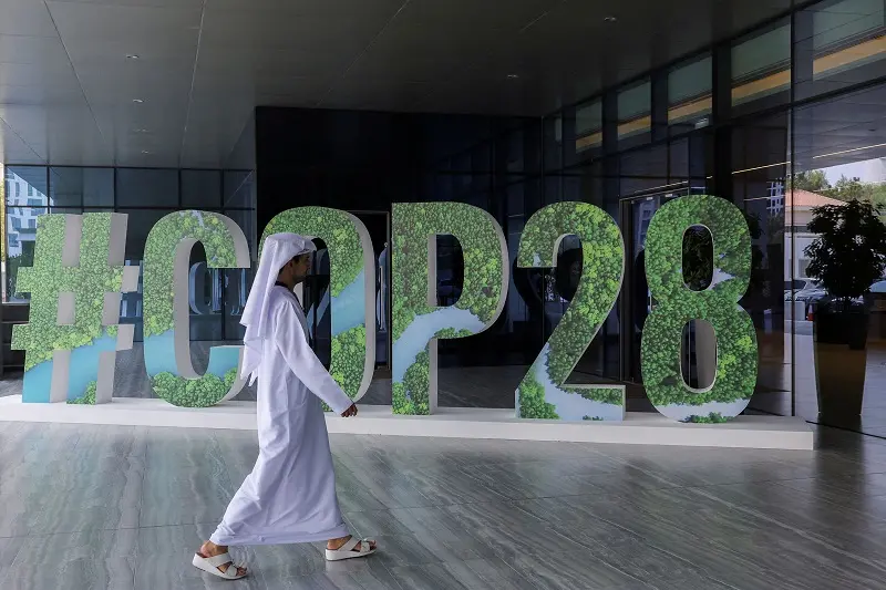 FILE PHOTO: A person walks past a \"#COP28\" sign during The Changemaker Majlis, a one-day CEO-level thought leadership workshop focused on climate action, in Abu Dhabi, United Arab Emirates, October 1, 2023. REUTERS/Amr Alfiky/File Photo