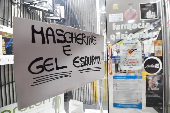 Un cartello esposto sulla vetrina esterna di una Farmacia genovese, che segnala l\\'esaurimento di gel disifettanti e mascherine di protezione per il viso. Genova, 25 Febbraio 2020.\\nANSA/LUCA ZENNARO