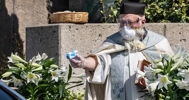 Coronavirus. Per rispettare le distanze il prete benedice i fedeli con una pistola ad acqua