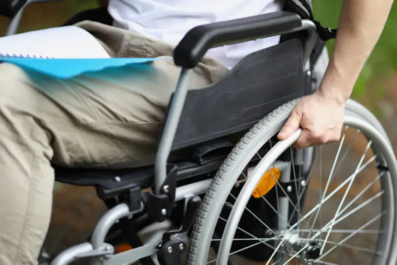 Man in wheelchair holds wheel with his hand. Rehabilitation of people with disabilities concept