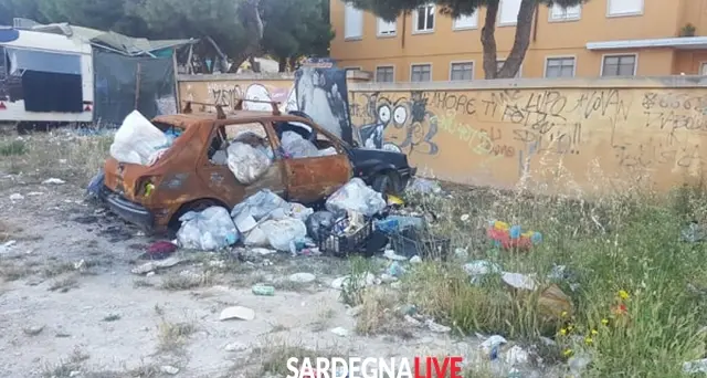 ‘Scheletri’ d’auto e bustoni colmi di rifiuti, benvenuti a Is Mirrionis. Le foto