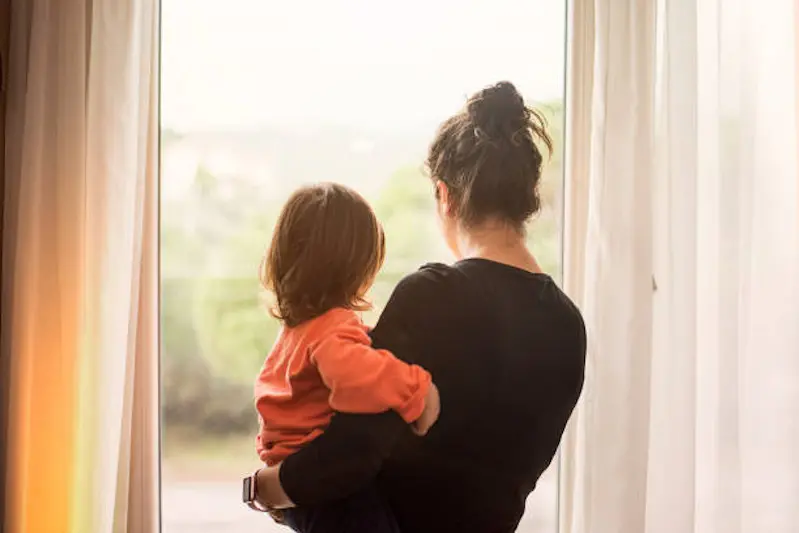 Mother and son looking out of window