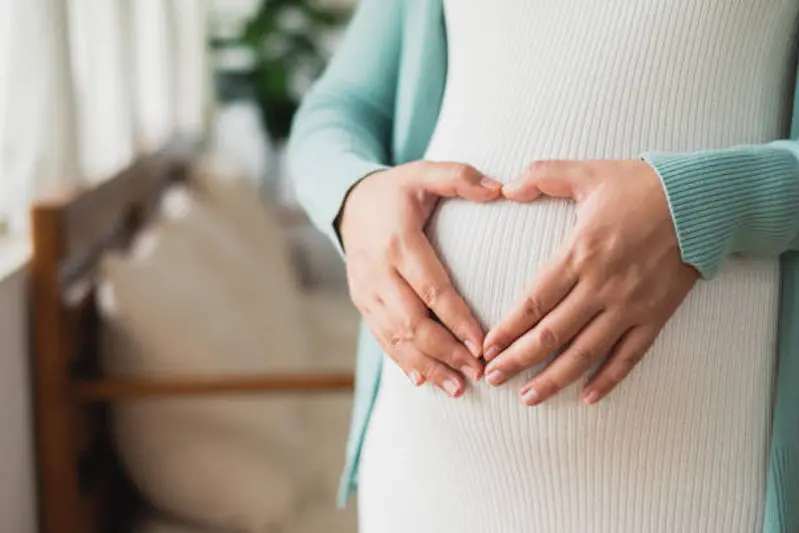 Pregnant woman making heart on big belly