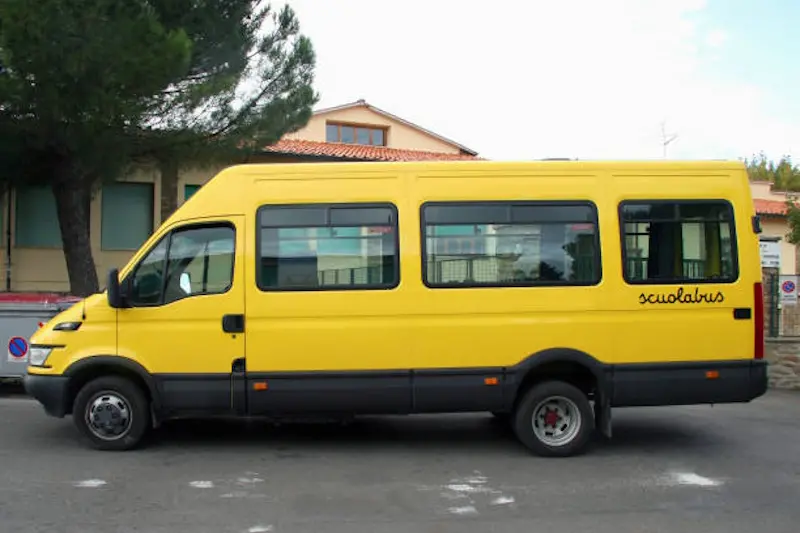 School bus parked in front of school building.