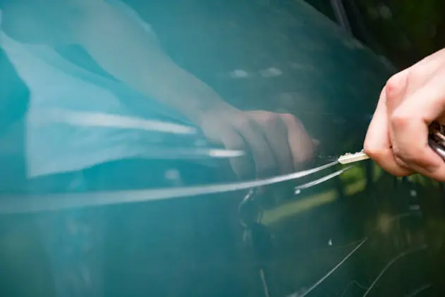 Adult Man Scratching Car Door With Keys.