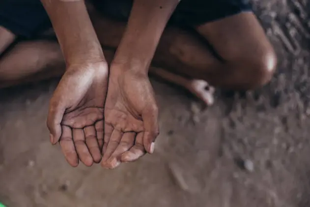 hands poor child or beggar begging you for help sitting at dirty slum. concept for poverty or hunger people,human rights,donate and charity for underprivileged children in third world