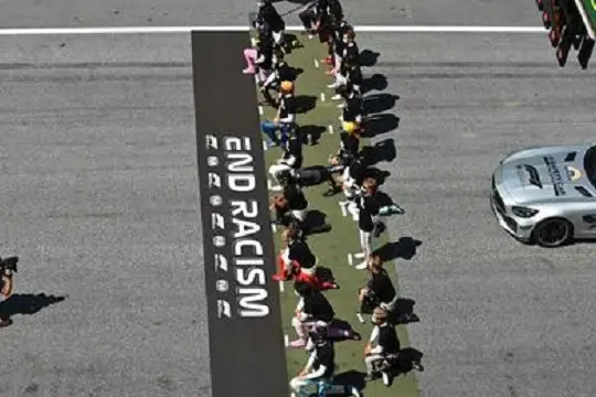 Drivers kneel behind a banner reading \"End Racism\" ahead the Austrian Formula One Grand Prix race on July 5, 2020 in Spielberg, Austria. (Photo by Joe Klamar / various sources / AFP)