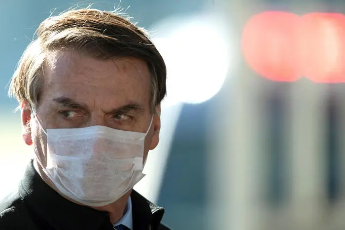 epa08452458 Brazilian President Jair Bolsonaro, wearing a face mask, leaves the Palacio do Alvorada, the official presidential residence in Brasilia, Brazil, 29 May 2020. Half of Brazilians disapprove of Bolsonaro\\'s management of the ongoing coronavirus pandemic, reports state, while only 27 percent approve of it. Brazil is confirmed as one of the epicenters of COVID-19 disease caused by the SARS-CoV-2 coronavirus. The Latin American country has the second-highest number of cases in the world and the sixth-highest number of virus deaths since the start of the pandemic.  EPA/Joedson Alves