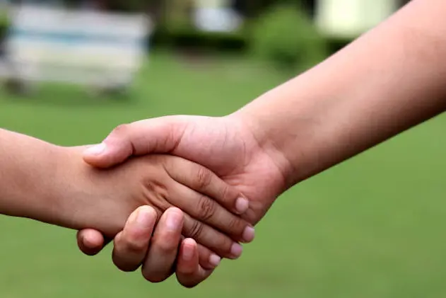 Low angle view of unrecognizable children  shaking hands in the park.