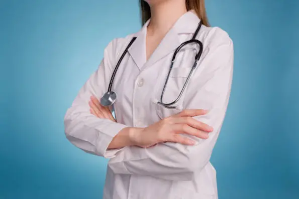 Close up of female doctor posing with arms crossed and stethoscope wear white coat, on blue  background. Portrait of professional confident young asian doctor. Healthcare and medical staff concept.