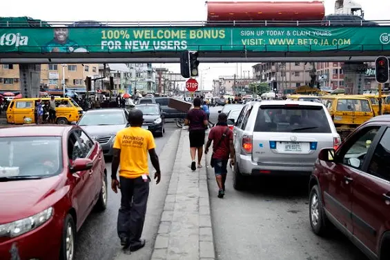 epa08534897 A banner advertising sport betting is seen hanging on a bridge in Lagos, Nigeria, 07 July 2020 (Issued 08 July 2020). Sport betting kiosks that were shut down during the long lockdown to prevent the spread of the coronavirus, are back on the streets as European premier leagues resume. Many Nigerians are followers of the Premier league and European football clubs and their fandom through betting is also huge, particularly in Lagos, a city of 21 million people.  EPA/AKINTUNDE AKINLEYE  ATTENTION: This Image is part of a PHOTO SET