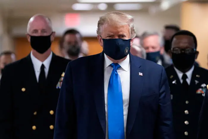 epa08541231 US President Donald J. Trump (C) wears a face mask as he arrives to visit with wounded military members and front line coronavirus healthcare workers at Walter Reed National Military Medical Center in Bethesda, Maryland, USA, 11 July 2020.  EPA/CHRIS KLEPONIS / POOL