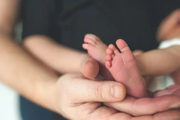 Newborns Little Feet in parents in parents hands