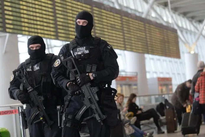 epa05225306 Polish Border Guard officers inside Warsaw Chopin airport, in Warsaw, Poland, 22 March 2016. The security level at Warsaw Chopin airport have been raised following the explosions in the departure hall of Zaventem Airport and on the metro system in Brussels, where dozens of people have died or been injured.  EPA/BARTLOMIEJ ZBOROWSKI POLAND OUT