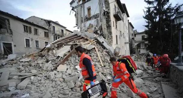 Profughi richiedenti asilo scavano tra le macerie con i soccorritori