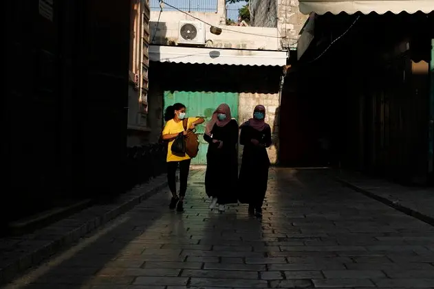 epa08659686 Palestinian women wearing protective face masks walk in an alley of Jerusalem\\'s old city, 10 September 2020. Israeli police began enforcing a night closures in more than 40 cities across the country as the coronavirus COVID-19 death toll in Israel has passed one thousand. The rate of morbidity and spread of the virus led to new government restrictions aimed to prevent the coronavirus COVID-19 outbreak.  EPA/ATEF SAFADI