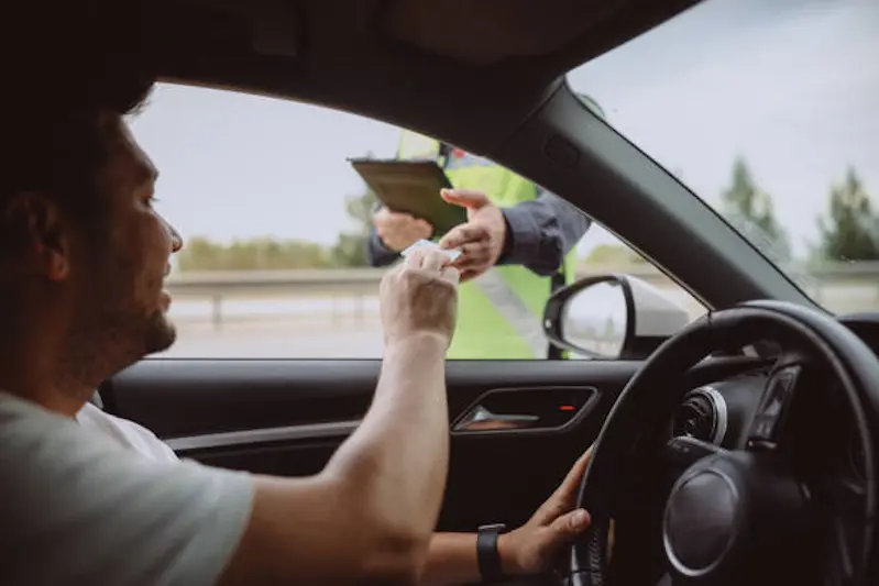 Close up person hand out of the car window holding the driver license as shows it to the police officer for control