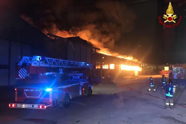 Il vasto incendio divampato stamani nel porto di Ancona. ANSA