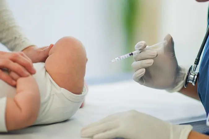 A baby is getting her vaccinations at the doctors office.