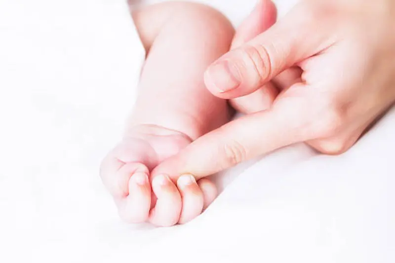 Mother\\'s finger and baby hand