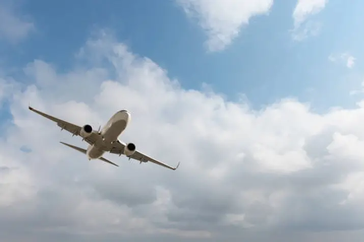 White passenger airplane flying in the sky amazing clouds in the background - Travel by air transport