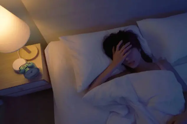 Top view asian woman laying on bed sleepless at night