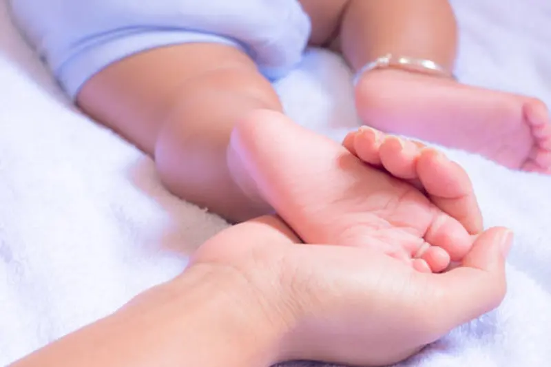 Baby feet in mother hands. Mother\\'s love for Baby concept.