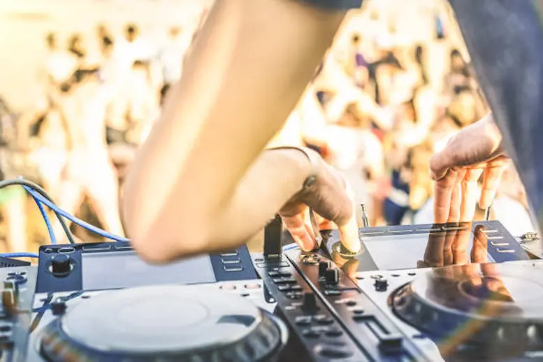 Close up of dj playing electro sound on modern cd usb player at summer beach party - Music festival and entertainment concept  - Defocused background with shallow depth of field - Focus on mixing hand