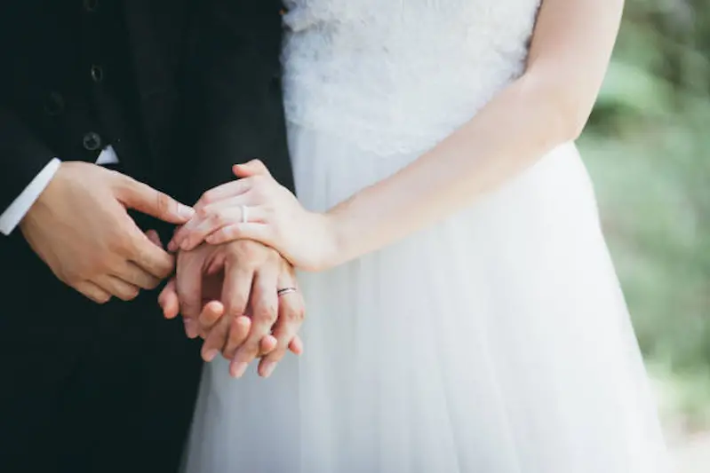 Close-Up Of Couple Holding Hands with wedding rings