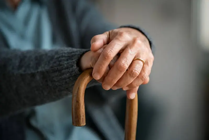 Close up of senior disabled woman hands holding walking stick. Detail of old woman hands holding handle of cane. Old lady holding walking stick.