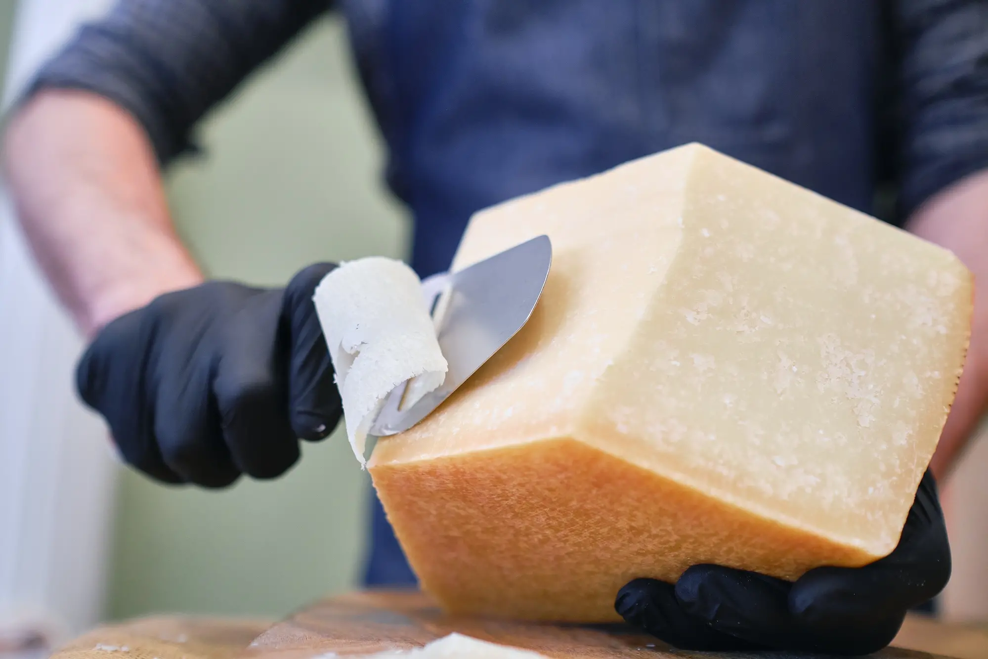 <p>A male staff slicing a block of cheese in a local supermarket</p>\\n